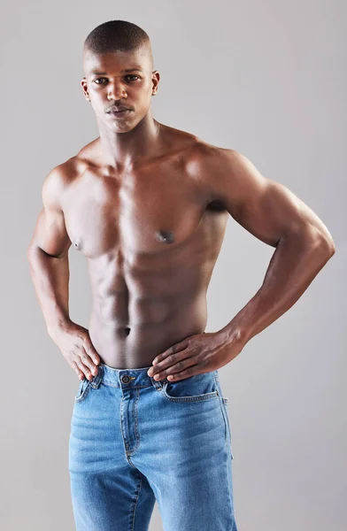 Not the type youd wanna let down. Studio portrait of a muscular young man posing against a grey background. Royalty Free Stock Images