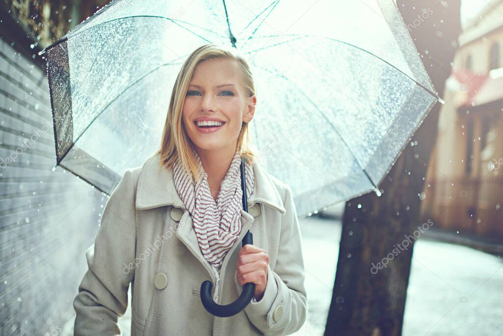 This weather wont get me down. Cropped portrait of an attractive young woman walking in the rain.