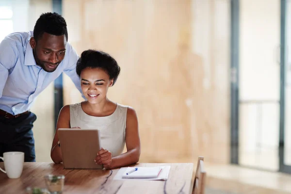 Lavorare per il successo un tocco alla volta. Colpo di colleghi che usano un tablet digitale insieme in un ufficio. — Foto Stock