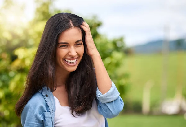 La sonrisa es el mejor accesorio que una mujer puede usar. Recortado disparo de una atractiva joven mujer de pie al aire libre. — Foto de Stock