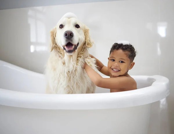 Étaient des garçons propres. Tourné d'un adorable petit garçon assis dans la baignoire avec son Golden Retriever pendant l'heure du bain à la maison. — Photo