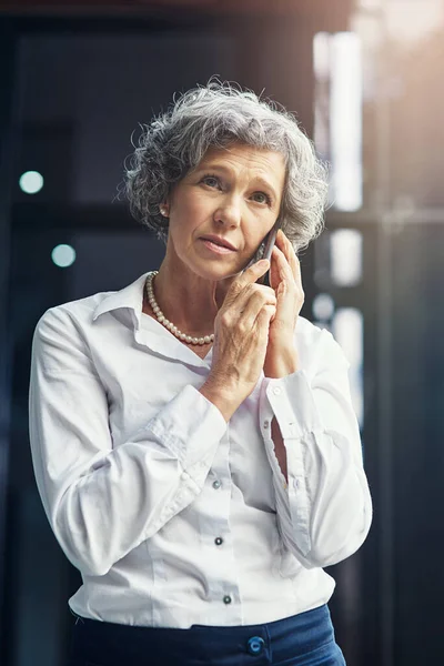 Er moet iets zijn wat we kunnen doen... een volwassen zakenvrouw die er bezorgd uitziet terwijl we praten op een mobiele telefoon.. — Stockfoto
