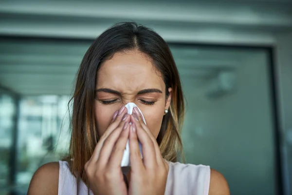 Bu alerjiler çok kötü. Ofiste burnunu silen genç bir iş kadınının fotoğrafı.. — Stok fotoğraf