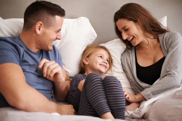 У ліжку з мамою і татом. Обрізаний знімок ласкавої молодої сім'ї, що лежить у ліжку разом . — стокове фото
