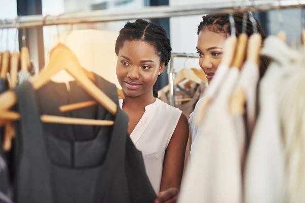 Entscheidungen, Entscheidungen.... Schnappschuss von zwei Frauen, die Kleidung auf einem Geländer in einem Geschäft betrachten. — Stockfoto