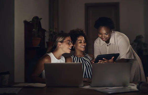 En büyük başarıların bazıları karanlıkta inşa edilir. Bir grup genç iş kadınının iş yerinde gece geç saatlerde dizüstü bilgisayar ve dijital tablet kullanırken çekilmiş fotoğrafı.. — Stok fotoğraf