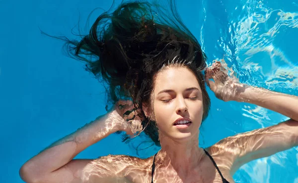 Summers aqui, hora de ir com o fluxo. Tiro de uma jovem mulher em uma piscina. — Fotografia de Stock