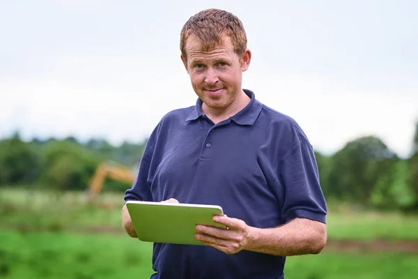 Κάνει τη γεωργία ευκολότερη με τη σύγχρονη τεχνολογία. Πυροβολισμός αγρότη με τη χρήση ψηφιακής πινακίδας στη φάρμα του. — Φωτογραφία Αρχείου