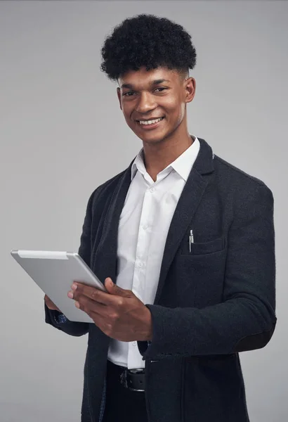 Sıkı çalış, akıllı ol. Genç bir iş adamının gri bir arkaplanda dijital tablet kullanırken çekilmiş bir fotoğrafı.. — Stok fotoğraf