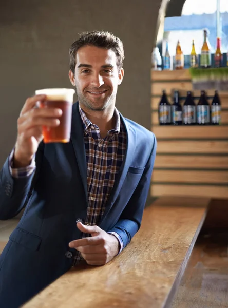 Ein Prosit auf Sie. Aufnahme eines hübschen jungen Mannes, der an der Bar ein Ale genießt. — Stockfoto