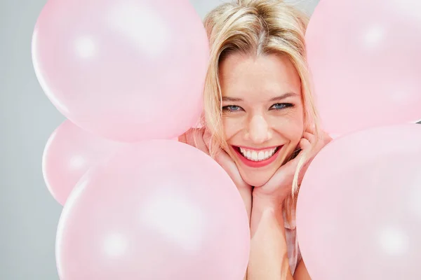 No estoy seguro de por qué, pero estoy tan feliz. Recortado disparo de una hermosa joven posando con globos de color rosa. — Foto de Stock