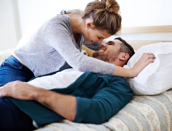 Les choses deviennent romantiques maintenant. Tourné d'un jeune couple heureux couché sur un lit ensemble. — Photo