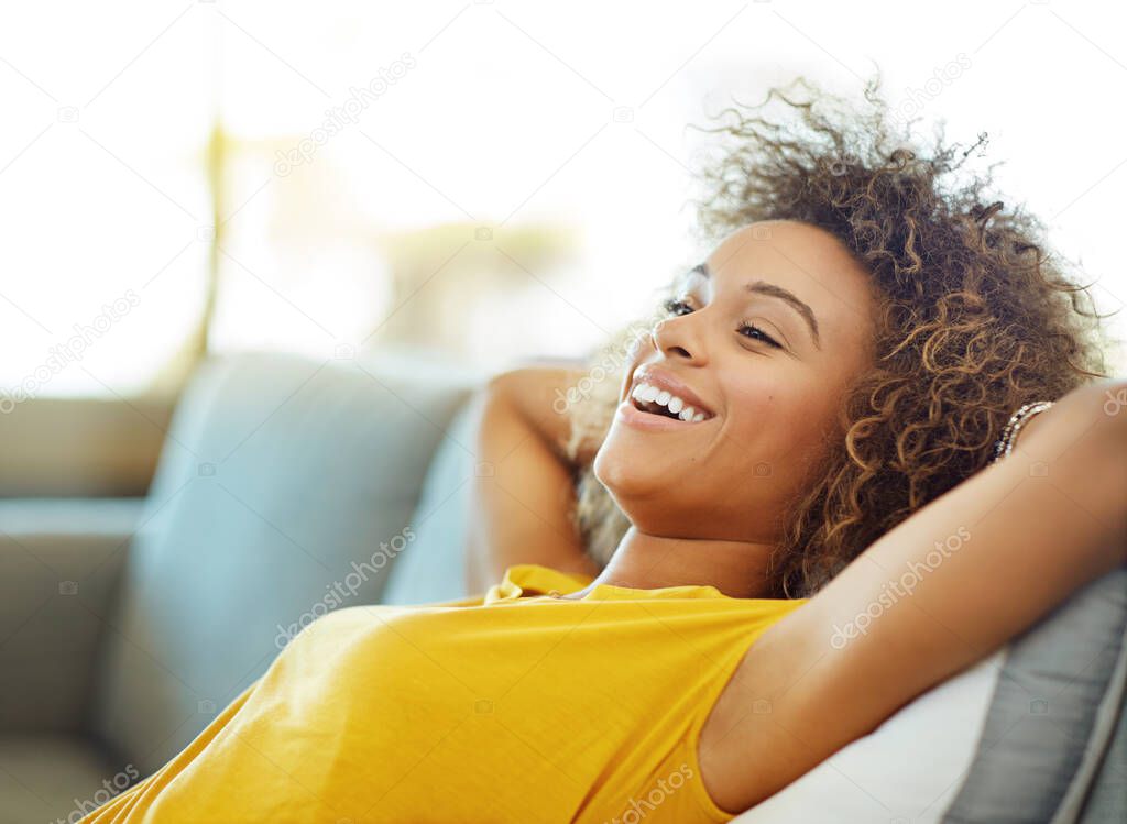 Let the relaxation begin. Shot of a young woman relaxing on the sofa at home.