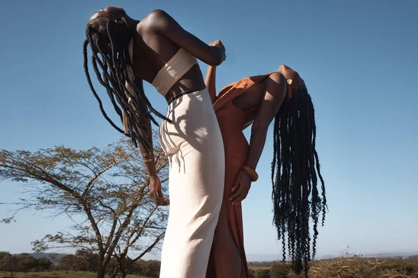 Niets kan ons afbreken als we elkaar opbouwen. Opname van twee aantrekkelijke jonge vrouwen die elkaars hand vasthouden tegen een Afrikaanse achtergrond. — Stockfoto