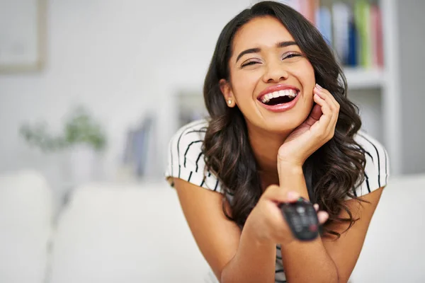 E 'la sua commedia preferita. Ritratto ritagliato di una giovane donna che guarda la TV mentre si rilassa sul suo divano a casa. — Foto Stock