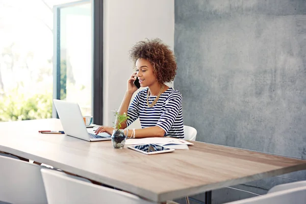 Haciendo nuevas conexiones. Fotografía de una joven hablando por teléfono mientras trabajaba en su escritorio en casa. — Foto de Stock