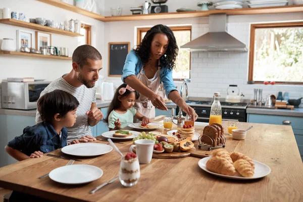 Iniziate la giornata con la colazione. Girato di una famiglia di quattro persone che fanno colazione insieme a casa. — Foto Stock