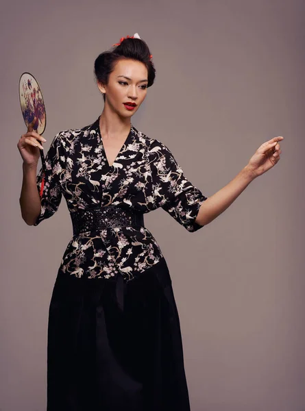 Kökleriyle bağlantı kuruyor. Geleneksel Asya kıyafetleri giymiş çekici bir genç kadının stüdyo fotoğrafı.. — Stok fotoğraf