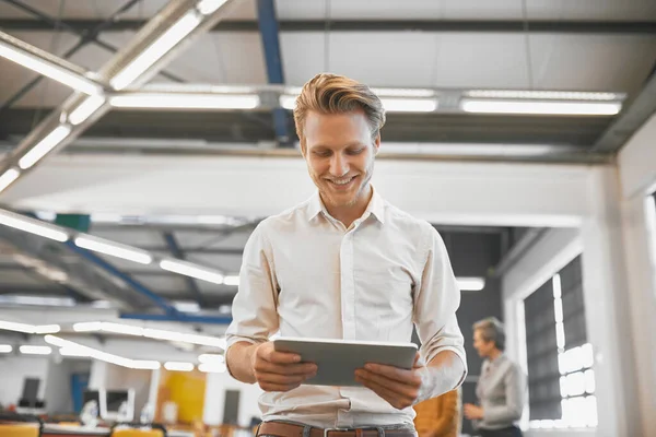 Hes working on something new and exciting. Cropped shot of a handsome young businessman using a tablet in his office. — Photo