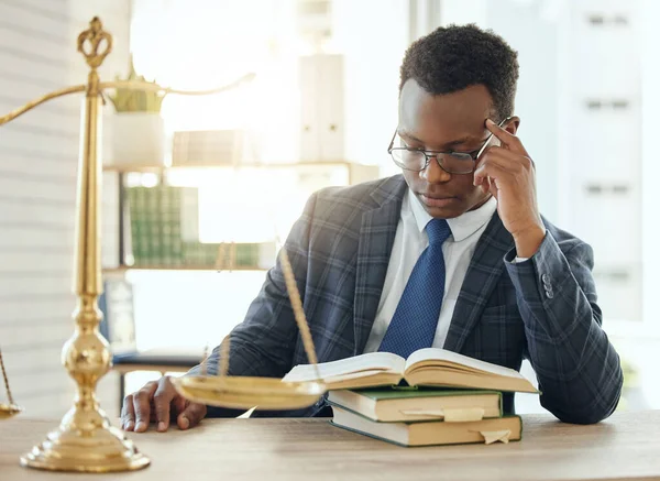 Reading up on an important case. Shot of a young male lawyer reading a book at work. — Stock Photo, Image