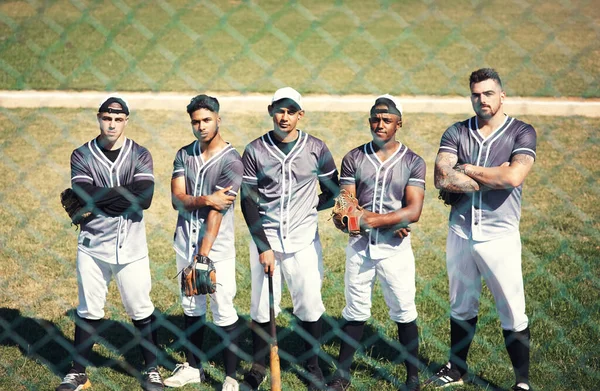 Vinnarna arbetar tillsammans som ett team. Porträtt av en grupp självsäkra unga män som spelar en omgång baseball. — Stockfoto