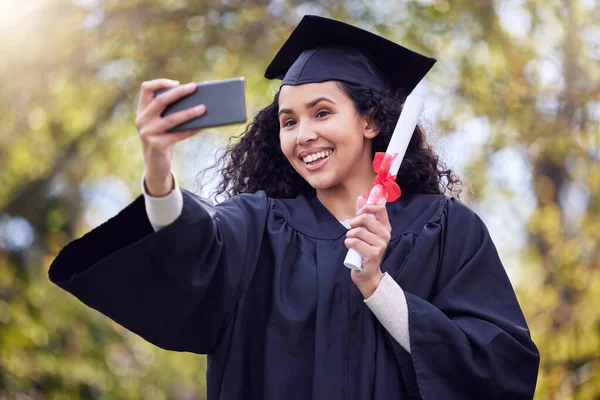 Learning looks good on you. Shot of a young woman taking a selfie on graduation day. — Photo