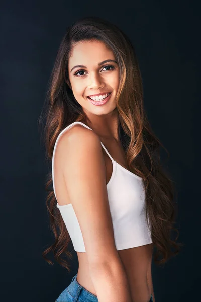 Boost your self confidence with a smile. Studio portrait of an attractive young woman posing against a dark background. — ストック写真