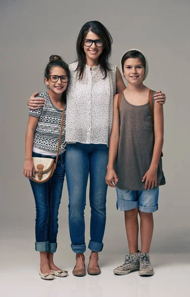 La famille est à la mode avant. Plan studio d'une mère branchée posant avec son fils et sa fille sur un fond gris. — Photo