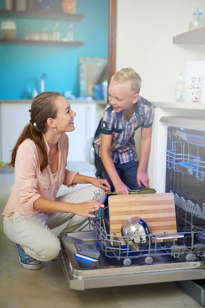Aiutarsi a vicenda e 'una gioia. Girato di una madre e un figlio utilizzando una lavastoviglie. — Foto Stock