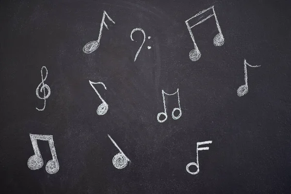 Laat de muziek je inspiratie zijn. Opname van verschillende muzieknoten op een krijtbord. — Stockfoto