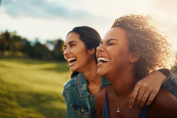 Friends who crack you up are the best. Cropped shot of two attractive young girlfriends having a laugh together at a park. —  Fotos de Stock