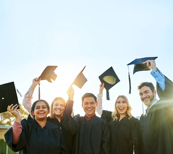 É incrível finalmente acabar o curso. Retrato de um grupo de estudantes comemorando no dia da formatura. — Fotografia de Stock