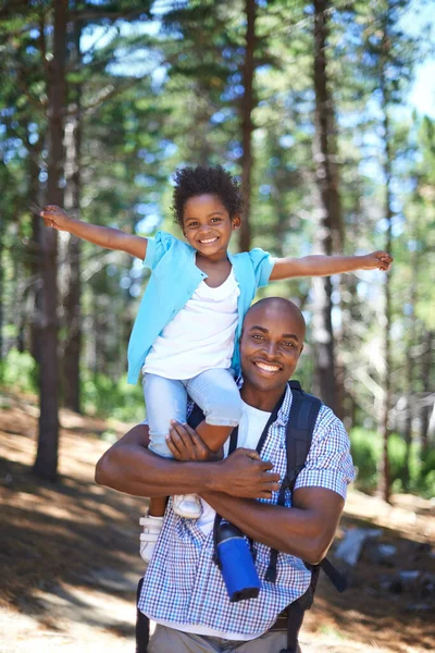 Njuter av naturen tillsammans. En glad ung afrikansk far leker med sin dotter medan utomhus i naturen. — Stockfoto