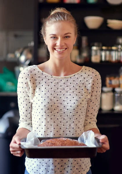 Pan casero saludable... deberías probar un poco. Retrato de una joven sosteniendo un pan recién horneado en una sartén. —  Fotos de Stock