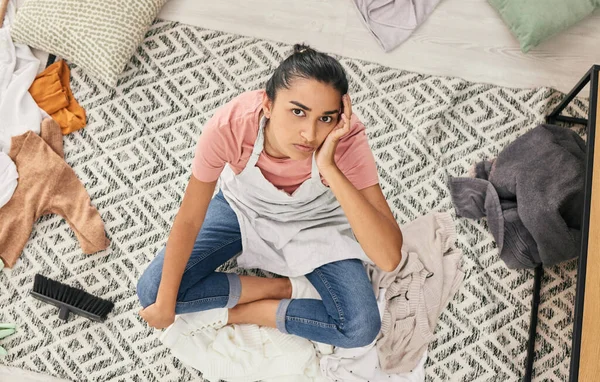 Não estou muito contente com isto. Tiro de uma jovem mulher sentada olhando oprimida enquanto sentada em uma sala de estar bagunçada em casa. — Fotografia de Stock