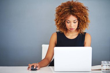İnternetteki iş varlığını arttırıyor. Masasında dizüstü bilgisayarla çalışan genç bir iş kadınının fotoğrafı..