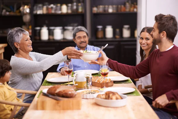Salade is verplicht aan deze tafel. Een opname van een gelukkig gezin die samen een maaltijd deelt. — Stockfoto