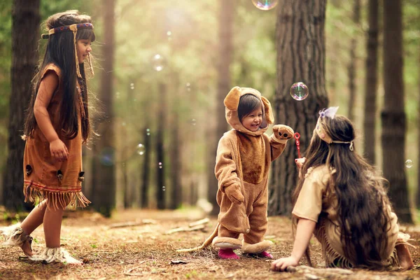 İnandırıcı topraklar. Üç küçük kızın ormanda giyinip kuşandığı uzun bir çekim.. — Stok fotoğraf