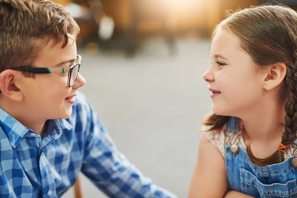 J'aime tes lunettes. Prise de vue de deux jeunes enfants travaillant ensemble dans une salle de classe pendant la journée. — Photo