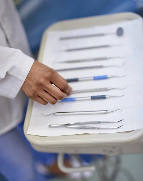 A alinhar ferramentas dentárias numa bandeja. Imagem de perto de um dentista irreconhecível que trabalha com uma bandeja de instrumentos cirúrgicos. — Fotografia de Stock