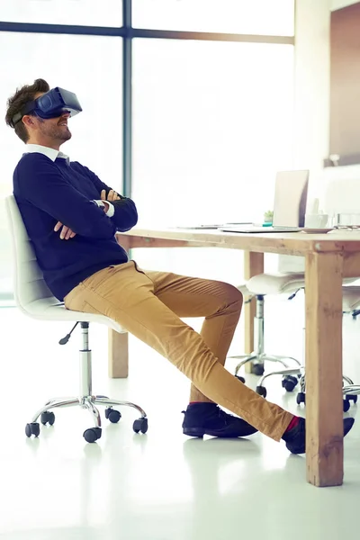Gelecek hiç bu kadar iyi görünmemişti. İş yerindeki sandalyesine yaslanırken VR kulaklık takan bir iş adamının fotoğrafı.. — Stok fotoğraf