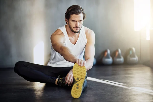 Si sta scaldando prima dell'allenamento. Girato di un bel giovane uomo che si scalda prima del suo allenamento. — Foto Stock