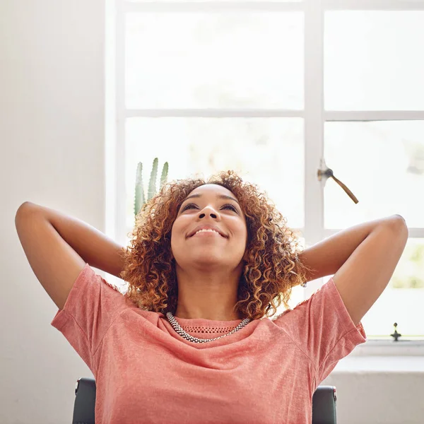 Mete-te no bom estado de espírito. Tiro de um jovem designer olhando relaxado no trabalho. — Fotografia de Stock