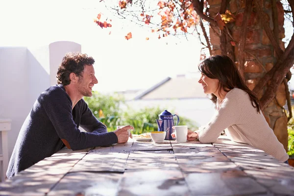 Une relation thé-temps. Un couple assis à une table en bois sous les feuilles d'automne. — Photo