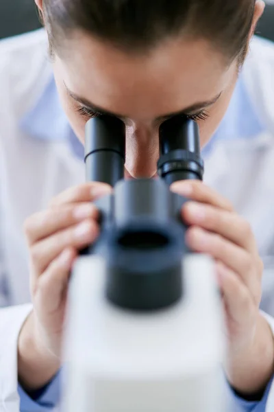 Zawsze jest coś nowego do odkrycia. Przycięte ujęcie młodej kobiety naukowca używającej mikroskopu w laboratorium. — Zdjęcie stockowe