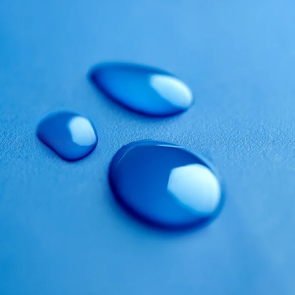 Trio in blue. Shot of drops of water. — Stock Photo, Image