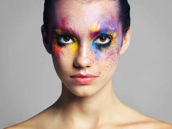 Because normal is just boring. Studio shot of an attractive young woman with brightly colored makeup against a gray background. —  Fotos de Stock