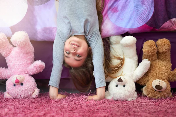 Ver el mundo desde una nueva perspectiva. Retrato de una linda niña haciendo un soporte de manos en su dormitorio en casa. —  Fotos de Stock