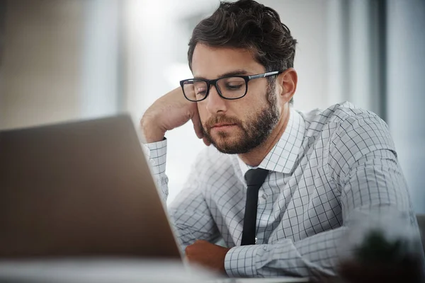 Talvez esteja na hora de mudar de carreira. Tiro de um jovem empresário olhando entediado enquanto trabalhava em um escritório. — Fotografia de Stock
