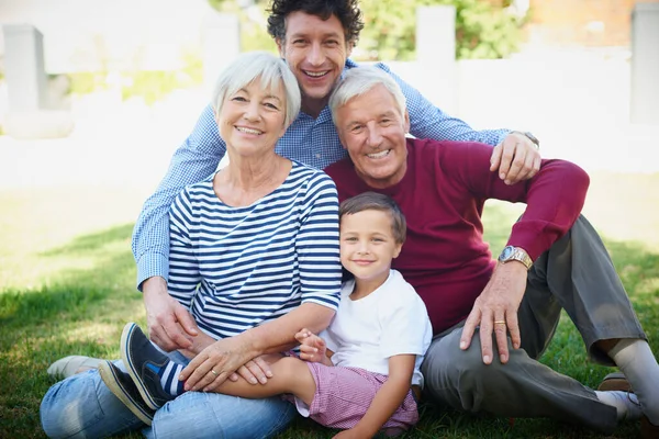 Ele ama os avós. Retrato recortado de uma família multi-geracional passar tempo juntos fora. — Fotografia de Stock